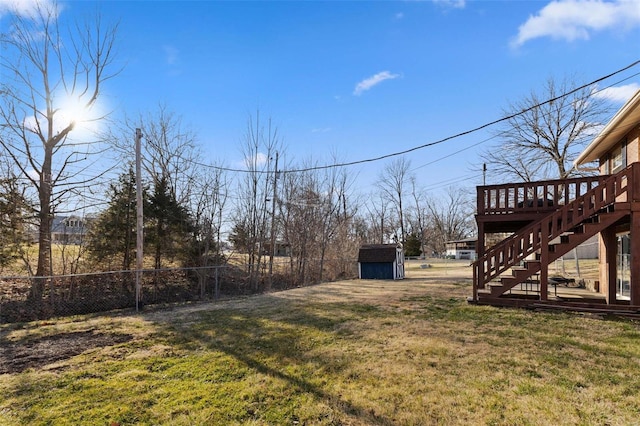 view of yard with fence, a shed, stairway, an outdoor structure, and a wooden deck