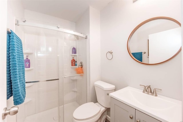 bathroom featuring a stall shower, vanity, and toilet