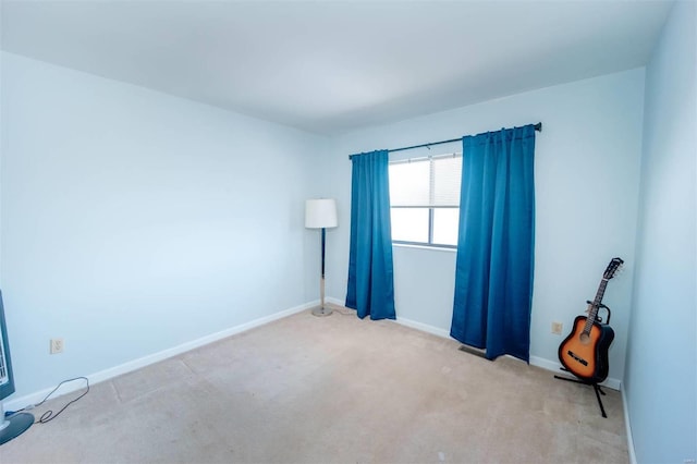 spare room featuring carpet and baseboards