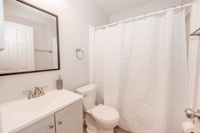 bathroom with toilet, curtained shower, and vanity