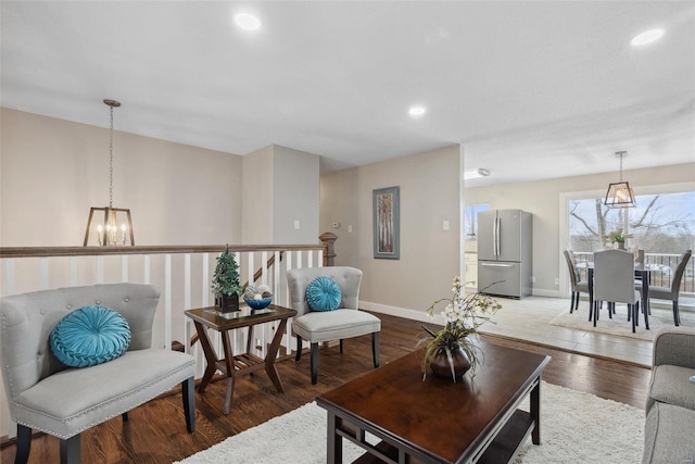 living area with a chandelier, recessed lighting, baseboards, and wood finished floors