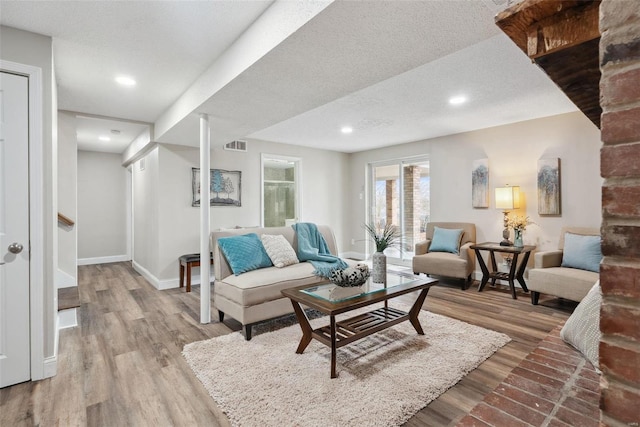 living area with baseboards, visible vents, wood finished floors, stairs, and a textured ceiling