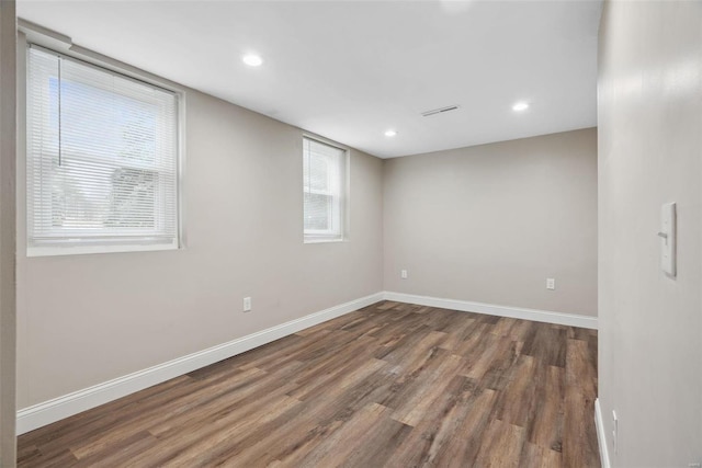 spare room featuring baseboards, wood finished floors, and recessed lighting