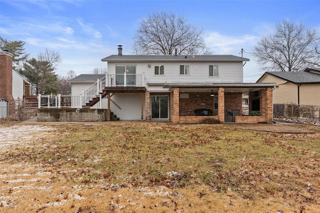 rear view of property with brick siding, a yard, stairway, a patio area, and fence