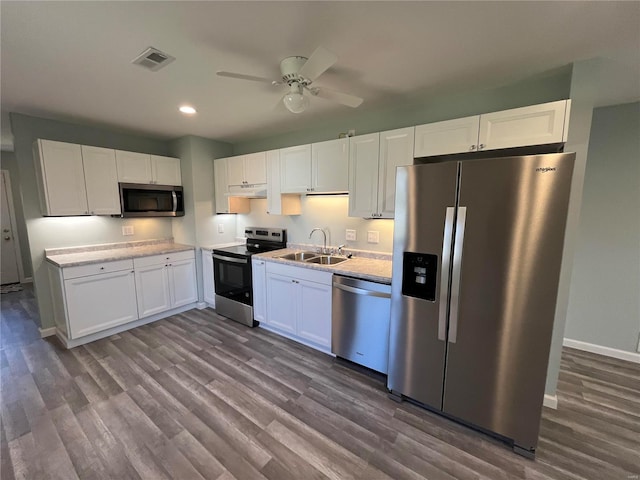 kitchen with visible vents, stainless steel appliances, a sink, and white cabinetry