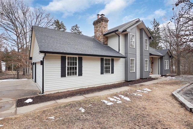 view of property exterior featuring a shingled roof and a chimney