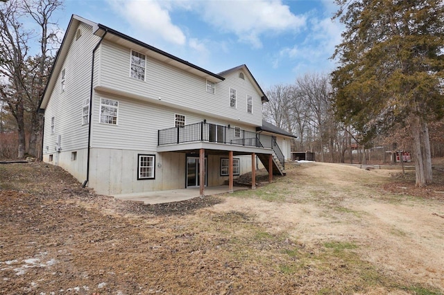 back of house with stairs, a patio, and a deck