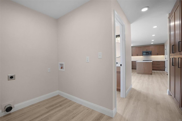 laundry area with baseboards, light wood-style flooring, washer hookup, and electric dryer hookup