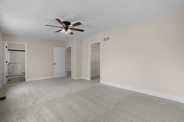 unfurnished bedroom with light colored carpet, visible vents, baseboards, a spacious closet, and a closet