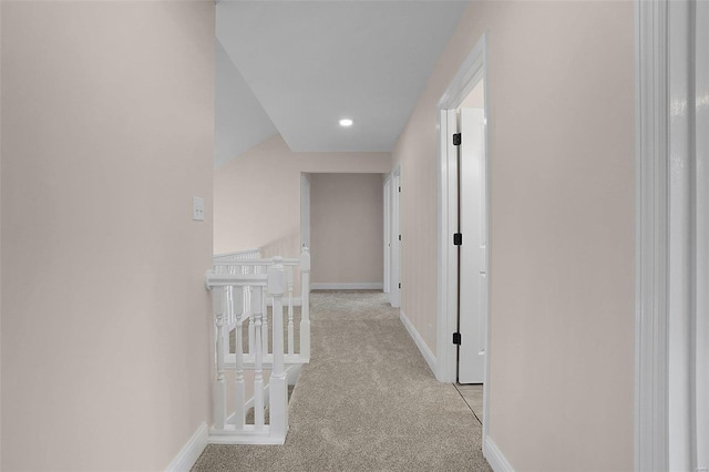 hallway with carpet floors, recessed lighting, baseboards, and an upstairs landing