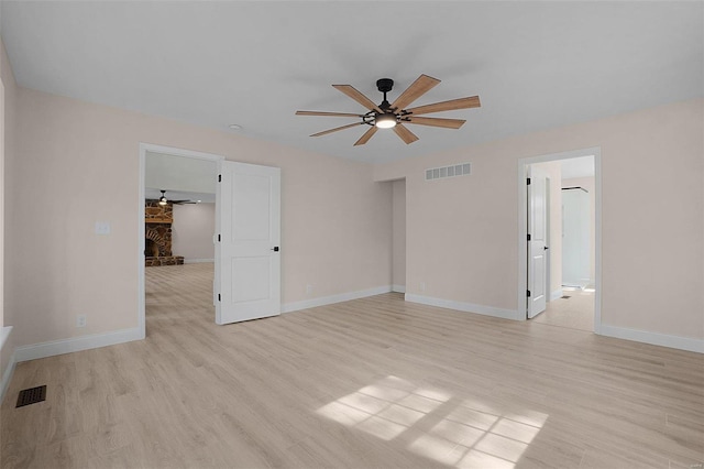 unfurnished room featuring light wood-style floors, baseboards, visible vents, and a ceiling fan