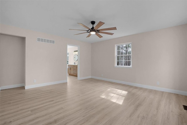 unfurnished room featuring light wood finished floors, a ceiling fan, visible vents, and baseboards