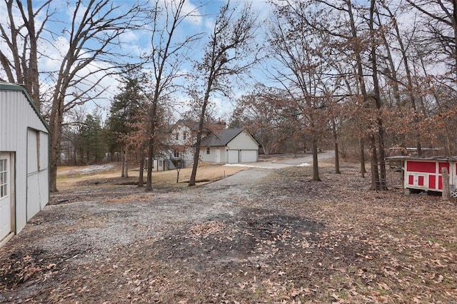 view of yard with an outdoor structure and dirt driveway