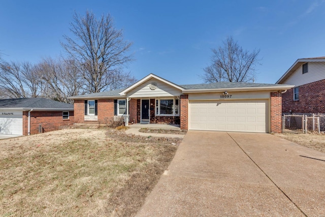 ranch-style house featuring driveway, an attached garage, fence, and brick siding