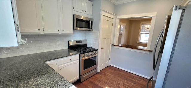 kitchen with appliances with stainless steel finishes, white cabinets, dark wood finished floors, and tasteful backsplash