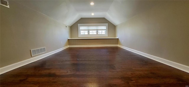 bonus room with dark wood-style floors, visible vents, vaulted ceiling, and baseboards