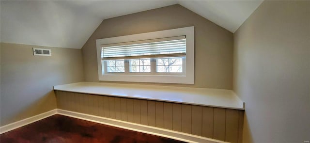 additional living space featuring lofted ceiling, baseboards, visible vents, and wood finished floors