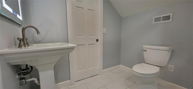 bathroom featuring marble finish floor, visible vents, toilet, vaulted ceiling, and baseboards