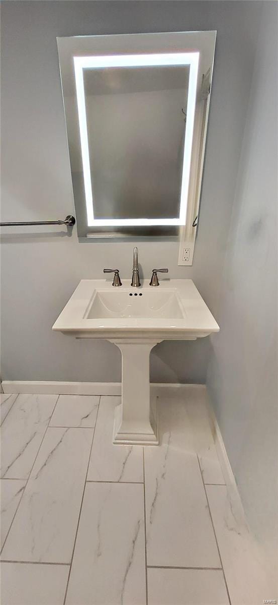 bathroom with marble finish floor and baseboards