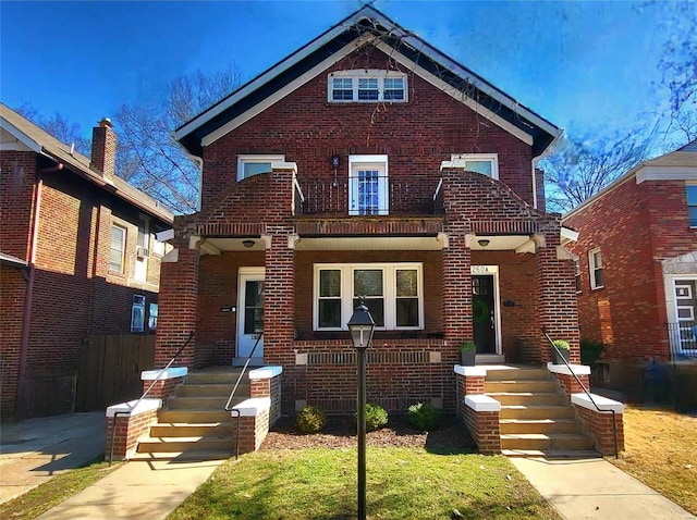 view of front of property featuring brick siding and a balcony