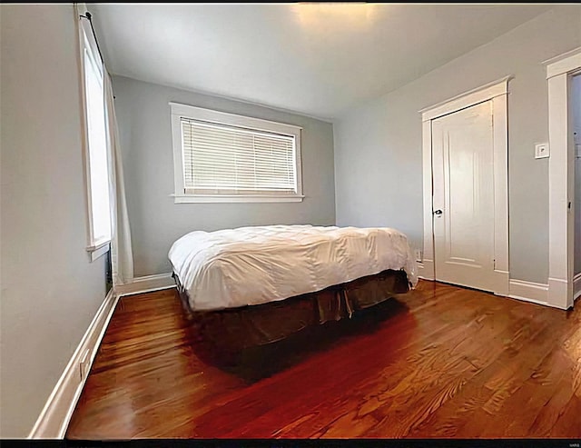 bedroom with baseboards and wood finished floors