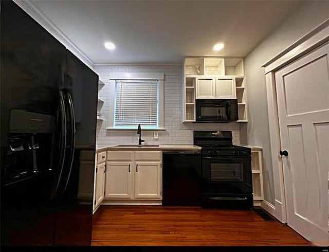 kitchen featuring open shelves, dark wood-type flooring, a sink, light countertops, and black appliances