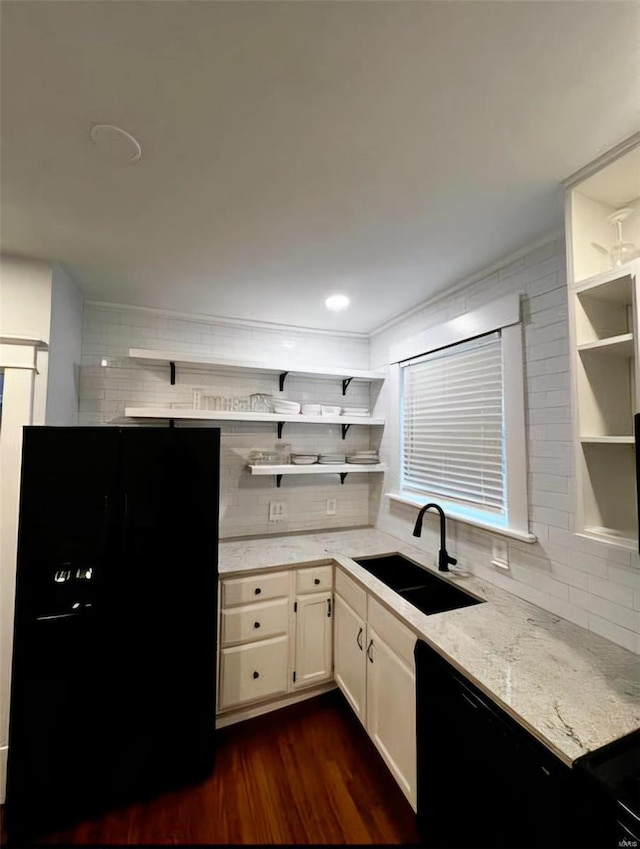 kitchen featuring tasteful backsplash, a sink, black appliances, and open shelves