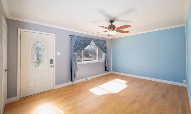 foyer entrance featuring crown molding, visible vents, baseboards, and wood finished floors