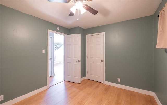 unfurnished bedroom with light wood-style flooring, baseboards, and ceiling fan