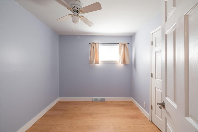 empty room with light wood-style floors, visible vents, ceiling fan, and baseboards