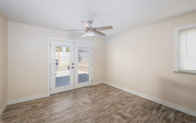 empty room featuring ceiling fan, baseboards, wood finished floors, and french doors