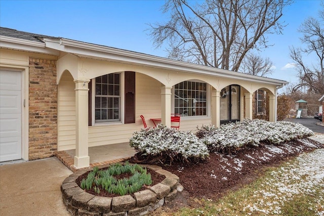 entrance to property featuring a porch and an attached garage