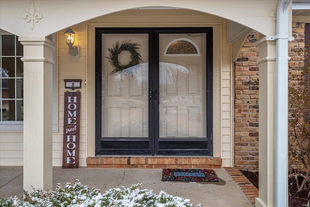 view of exterior entry featuring stone siding and brick siding