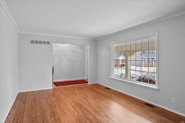 empty room featuring visible vents, baseboards, and wood finished floors