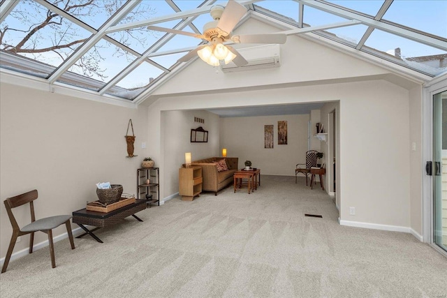 sitting room with carpet floors, lofted ceiling with skylight, a ceiling fan, a wall mounted air conditioner, and baseboards