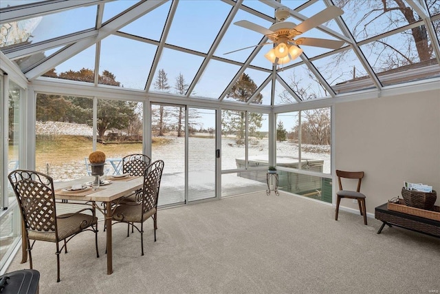 sunroom / solarium with a ceiling fan and a water view