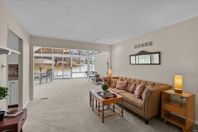 living area featuring a sunroom, carpet flooring, and visible vents