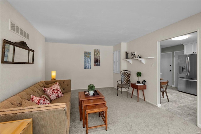 living room with baseboards, visible vents, and light colored carpet