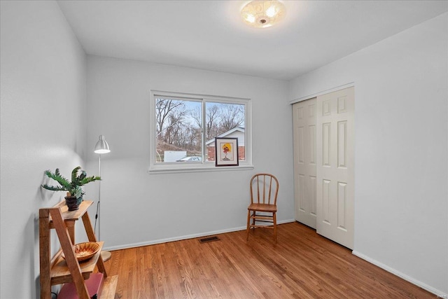 interior space with visible vents, baseboards, and wood finished floors