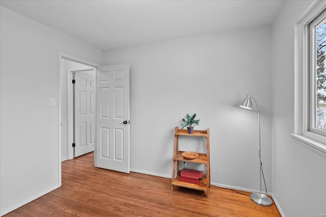 interior space with plenty of natural light, wood finished floors, and baseboards