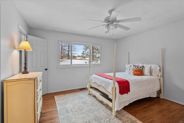 bedroom with baseboards, light wood finished floors, visible vents, and a ceiling fan