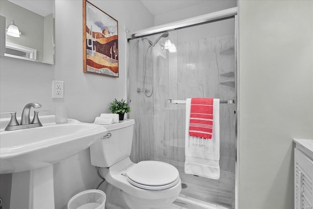 bathroom featuring a stall shower, a sink, and toilet