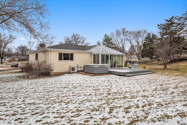 back of property featuring a hot tub and a deck