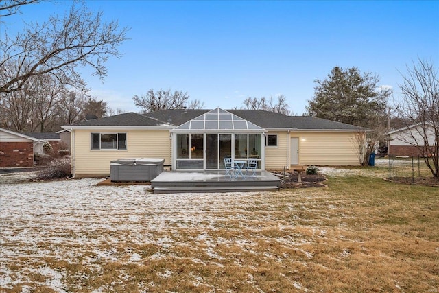 back of house with a yard, a wooden deck, a sunroom, and a hot tub