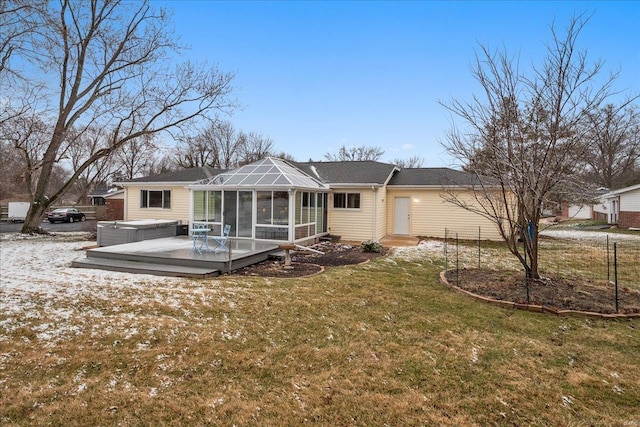 rear view of house featuring a yard and a sunroom