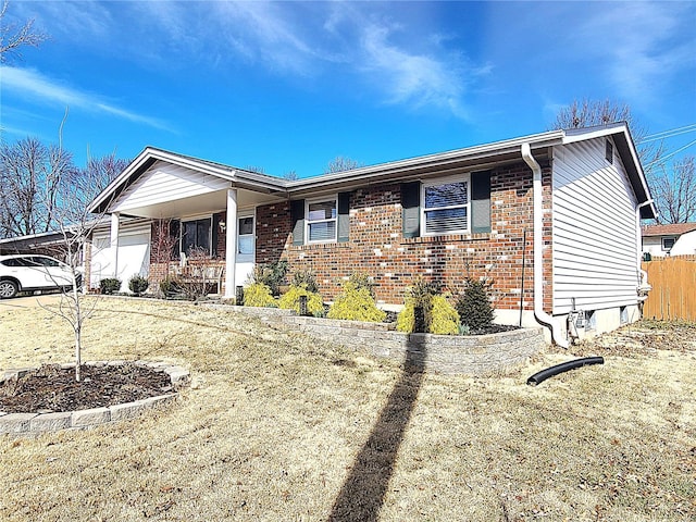 ranch-style home featuring brick siding and fence