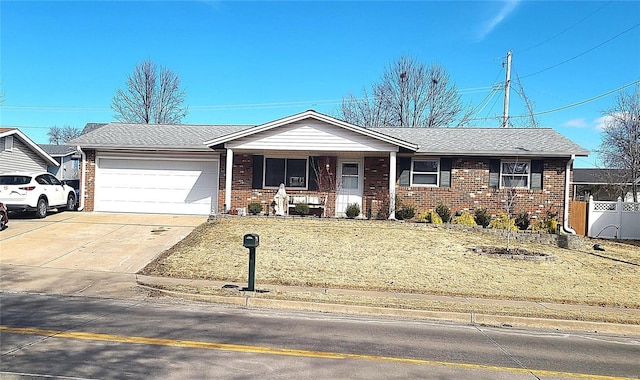 single story home with a garage, a shingled roof, concrete driveway, fence, and brick siding