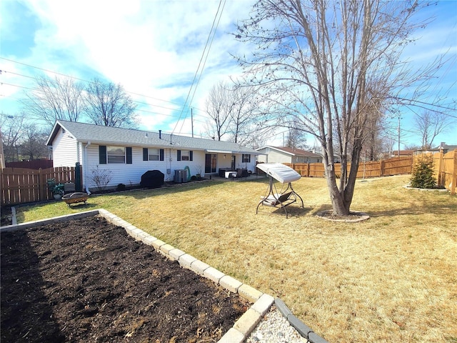 exterior space with a fenced backyard, cooling unit, and a lawn