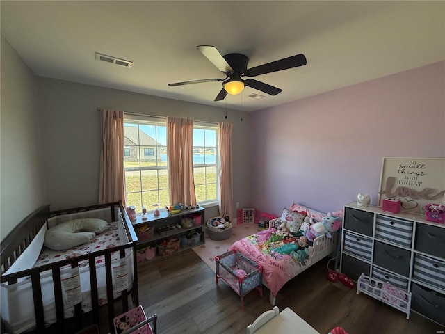 bedroom featuring visible vents, ceiling fan, and wood finished floors