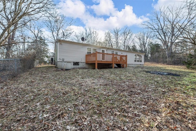 back of house featuring fence and a wooden deck